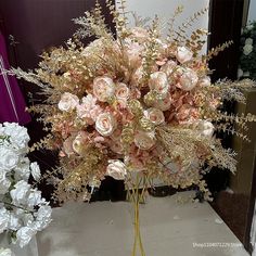 a bouquet of pink flowers sitting on top of a table next to some white flowers