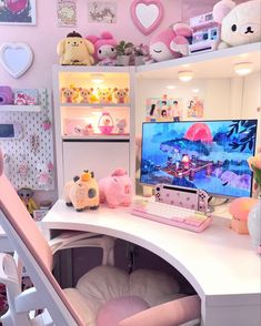 a desk with a computer on it and stuffed animals in the corner next to it