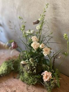 some white flowers and green moss on a table