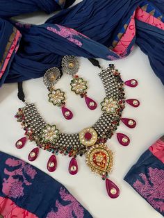 Designer Festive Fusion Meenakari Kundan stones studded Dual tone oxidized Necklace set. Dark Pink Long Bead drops with multicolor onyx makes this piece of jewelry so festive. Drawstring adjustable. Matching earrings included. Ethnic jewelry. Festive Jewelry. Navratri Jewelry. ✅ WHAT GOES IN  👉🏻Premium Quality raw materials. 👉🏻Super light weight earrings. ✅Check our collection here https://www.etsy.com/shop/KKsCulture ✅Contact Us if you need help : Email: kksculture [!at] gmail.com | Phone : Kundan Jewelry With Motifs For Navratri, Navratri Kundan Jewelry With Motifs, Multicolor Heavy Jewelry For Celebration, Multicolor Celebration Jewelry, Traditional Jeweled Kundan Necklace For Festive Season, Traditional Jewelry Sets With Motifs For Festive Season, Traditional Festive Jewelry Sets With Motifs, Ceremonial Multicolor Jewelry, Traditional Jeweled Chandbali Kundan Necklace