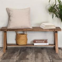 a wooden bench with two books and a basket on the bottom shelf next to it