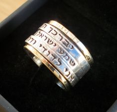 "Handmade Original Inscribed Hebrew 3 Spin Ring: 1) \"יברכך ה' וישמרך\" (\"The Lord Bless You & Keep You\") 2) שמע ישראל ה' אלוהינו ה' אחד (Hear O Lord is our God the LORD is One) 3) אני לדודי ודודי לי (I am My Beloved's and my beloved us mine). Description: ❇ Free worldwide shipping ❇ Material: 9k Solid Gold & Sterling Silver 925. ❇ Width (approx.): 2.0cm (0.79 inches) ❇ All Jewelry items are shipped inside a fancy gift box. ❇ All of my designs are HANDMADE. The inscription אני לדודי ודודי לי i Silver Engraved Ring Stamped 14k For Promise, Spiritual Anniversary Engraved Ring, Silver Stackable Wedding Rings Stamped 14k, Wide Band Stamped Rings For Anniversary, Spiritual Personalized Promise Rings, Promise Engraved Ring With Names, Promise Ring Engraved With Names, Symbolic Engraved Stackable Rings For Anniversary, Symbolic 14k Stamped Wedding Rings