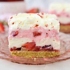 there is a piece of cake on the plate with strawberries and cream frosting