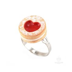 a heart shaped pastry on top of a silver ring