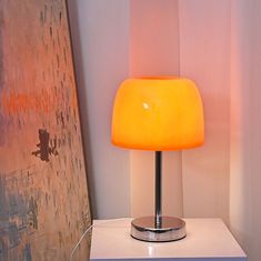 an orange lamp sitting on top of a white table