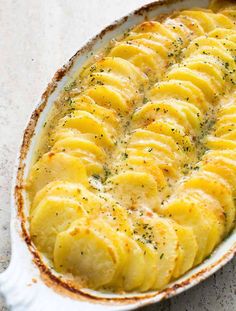 a casserole dish filled with potatoes and herbs