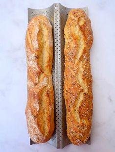 two loaves of bread sitting on top of a metal rack