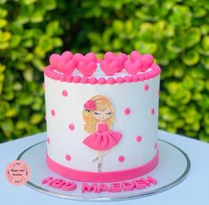 a white and pink cake with a barbie doll on it