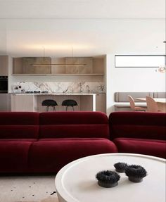 a living room filled with furniture next to a kitchen