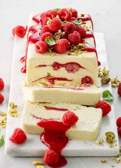 raspberry cheesecake with whipped cream and pistachio toppings on a white platter