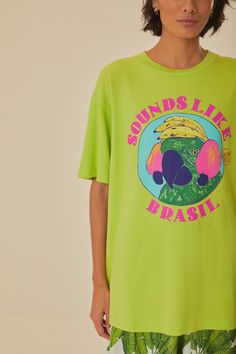 Immerse yourself in tropical vibes with the Green Sounds Like Brasil Organic Cotton T-Shirt by FARM Rio. This vibrant piece features a lively round neckline and a relaxed fit that drapes effortlessly for a comfy yet stylish feel. The bright green hue serves as a canvas for a playful parrot graphic, encapsulated with bold, lively text, offering a burst of Brazilian spirit. Crafted from soft organic cotton, this tee invites a touch of nature's comfort to your everyday wardrobe. Composition 100% COTTONCare Instructions MACHINE WASH, GENTLE CYCLE, DO NOT BLEACH, DO NOT TUMBLE DRY, LINE DRYING, IRON AT MEDIUM HEAT, DRY CLEAN WITH ANY SOLVENT EXCEPT TRICHLOROETHYLENESize and Fit Inches XXS XS S M L XL Bust 40 2/4 42 2/4 44 2/4 46 2/4 49 2/4 52 2/4 Waist 40 3/4 42 3/4 45 46 3/4 49 3/4 52 3/4 Leng Casual Green Printed Tops, Green Printed Crew Neck Top, Green Casual Vacation Tops, Green Cotton Tops With Front Print, Vibrant Green Tropical Print Top, Trendy Green Printed Top, Cotton Tropical Print T-shirt, Green Trendy Top With Graphic Print, Trendy Green T-shirt For Vacation