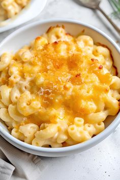 two bowls filled with macaroni and cheese on top of a table