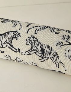 a black and white tiger pattern on a roll of fabric with an eyeglass case in the foreground