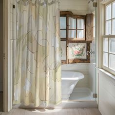 a bathroom with a tub, shower curtain and window in it's center area