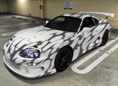 a white sports car parked in a parking garage