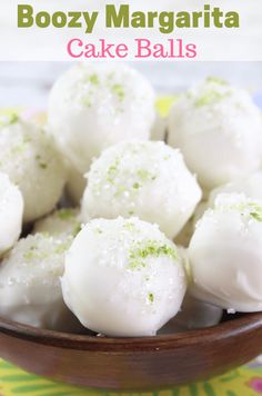 a bowl filled with cake balls covered in green sprinkles on top of a table