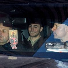 two men sitting in the back seat of a car