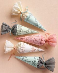 four small cones with bows on them are lined up in a row against a pink background