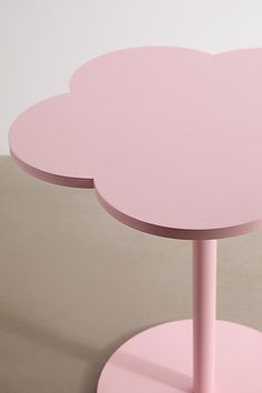 a pink table sitting on top of a white floor