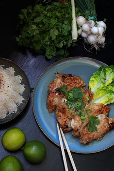 some food is on a plate with chopsticks next to it and limes