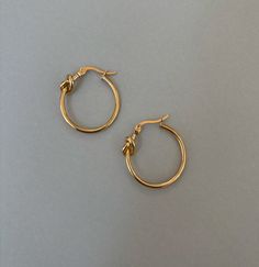 SMALL GOLD KNOT HOOP EARRINGS Materials: Stainless steel, 18K gold plated Stud Measurements: 23mm inner diameter, 25mm outer diameter, 1.5mm thickness Closure: latch back Additional Info: High polish Finish Hypoallergenic Eco-friendly: We use sustainable metals and recycled gold tarnish resistant and waterproof All of our gold jewelry is plated with recycled gold. Each piece is coated using the highest grade technique, which is made to be 8 times more durable than traditional gold-plated jewelry Traditional Small Hoop Earrings, Sample Sale, Recycled Gold, Gold Plated Jewelry, Sale Items, Gold Jewelry, 18k Gold, Gold Plate, Hoop Earrings