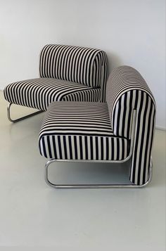 a black and white striped chair sitting on top of a white floor next to a wall