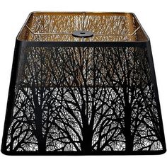 a lamp shade with trees on it and the bottom half cut out to look like branches