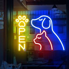 a neon sign with a dog's head and paw on it in front of a store window