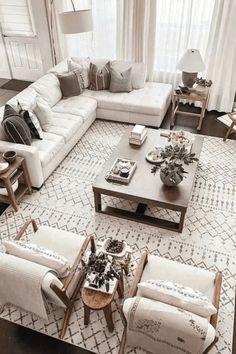 a living room filled with white furniture and lots of pillows on top of it's couches