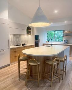 a kitchen with an island and three stools