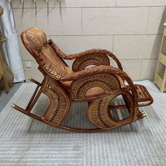 a wooden rocking chair sitting on top of a carpeted floor next to a wall