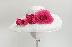 A truly elegant statement ivory and cerise pink wide brim occasion hat.  This beautiful headpiece is made in ivory sinamay straw with a flattering drop brim. The standout feature of this hat is the handmade silk dupion and organza layered rose in the most gorgeous shade of cerise, fuchsia  pink, with five matching buds that trail across the front brim. The crown is wrapped in a matching band of fuchsia silk dupion.  Measuring 44cm side to side, and 35cm front to back, and is made to a standard 2 Chic Pink Sun Hat With Flat Brim, Chic Pink Sun Hat For Kentucky Derby, Elegant Pink Brimmed Hats, Elegant Pink Hat For Kentucky Derby, Elegant Pink Hat With Short Brim, Chic Pink Hat With Curved Brim, Feminine Pink Hat With Curved Brim, Chic Pink Hat For Wedding, Chic Pink Sun Hat With Short Brim