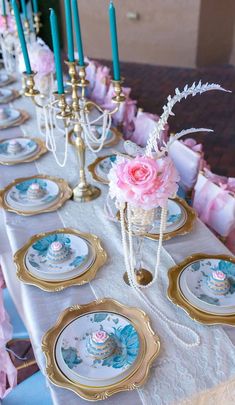 the table is set with pink flowers and blue candlesticks for an elegant touch