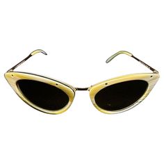 These sunglasses exude a vintage, high-fashion appeal with their cat-eye shape and textured design. The combination of light-colored acetate with metallic details gives them an elegant and timeless feel typical of Tom Ford's aesthetic, which often merges retro inspiration with modern luxury The sunglasses feature a bold cat-eye frame, a popular style in vintage fashion, particularly reminiscent of the 1950s and 1960s. The pointed upper corners give it a sophisticated and dramatic look. The frame has a light yellow or cream-colored pattern, resembling horn or tortoiseshell texture with subtle, wavy lines across the surface. The lines are soft and flowing, giving a natural, organic aesthetic to the glasses. The sunglasses are in good conditions. They are in very good condition overall Luxury Vintage Brown Cat Eye Sunglasses, Sunglasses Yellow, Retro Inspiration, Organic Aesthetic, Tom Ford Handbags, Plastic Sunglasses, Wavy Lines, Blue Sunglasses, Vintage Mode