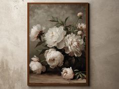 a painting of white flowers in a vase on a wall next to a brown frame