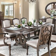 a dining room table and chairs with chandelier in the background on carpeted floor