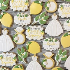 some decorated cookies are sitting on a wooden table with white and yellow icing around them