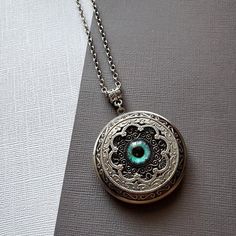 Large Locket Dragon Eye Necklace ☻Locket ~ Large, Decoratively Styled ~ Measures 1.77 inches round See Photos for size comparison against American quarter Chain: ~ Silver Plated YOU CHOOSE YOUR CHAIN LENGTH during checkout ☻More Lockets Here: https://www.etsy.com/shop/FashionCrashJewelry/search?search_query=lockets&order=date_desc&view_type=gallery&ref=shop_search ☻Link to The ENTIRE SHOP: https://www.etsy.com/shop/FashionCrashJewelry?ref=shopsection_shophome_leftnav&ga_search_qu Green Round Locket Necklace, Amulet Style Round Pendant Locket Jewelry, Green Locket Necklace With Round Pendant, Amulet Style Locket Jewelry, Round Amulet Locket Jewelry, Round Locket Amulet Jewelry, Vintage Round Pendant Jewelry For Festivals, Metal Round Pendant Jewelry For Keepsake, Turquoise Engraved Amulet Jewelry