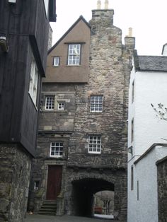 an old stone building with stairs leading up to the door and windows on each side