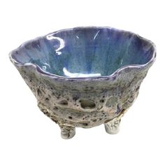 a blue and white bowl sitting on top of a wooden stand with holes in it