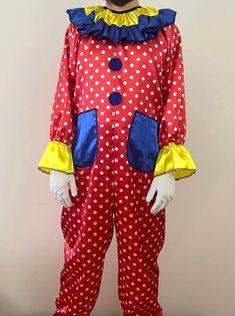 a person in a red and white polka dot clown costume standing on a wooden floor