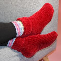 a person wearing red socks and striped socks sitting on a gray couch with their feet up