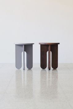 two small tables sitting on top of a white floor