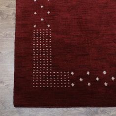 a red area rug with white stars and dots on the bottom, in front of a wooden floor