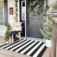 the front porch is decorated for christmas with wreaths