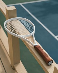 a tennis racquet resting on top of a wooden racket