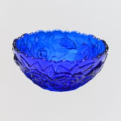 a blue glass bowl sitting on top of a table