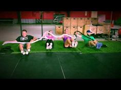 four people sitting on the ground in a crossfit gym doing exercises with ropes