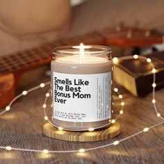 a candle sitting on top of a table next to a string of lights and a guitar