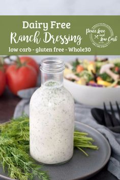 dairy free ranch dressing in a glass bottle on a plate with fresh vegetables and salad behind it